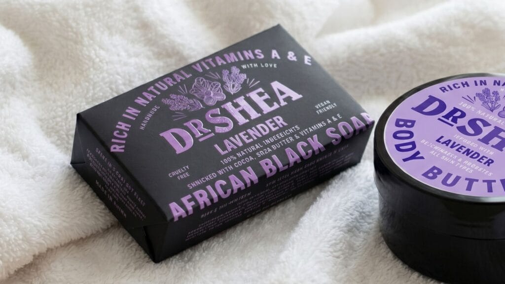 handmade lavender african black soap bar for eczema relief and lavender body butter on a white towel.